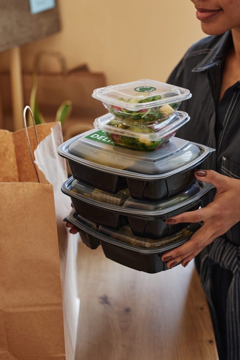 Young Black woman unpacking food delivery order at home kitchen Closeup of young Black woman unpacking food delivery order at home, copy space